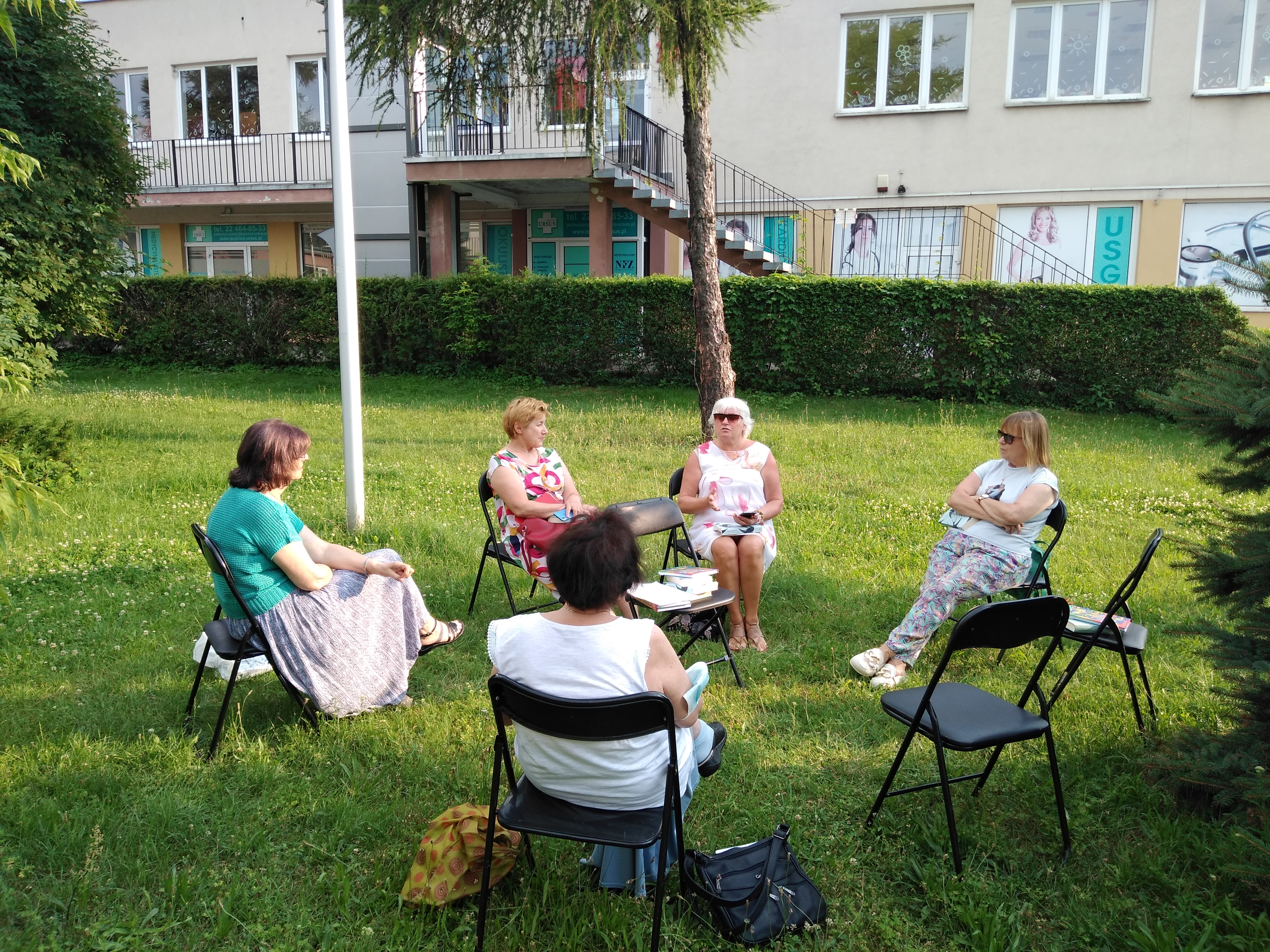 IMG_20210712_182419040 Pięć kobiet siedzących w kręgu na krzesłach na trawie.