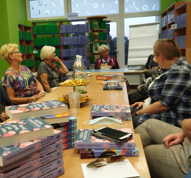 DKK Kobiety siedzą przy stole, na którym jest dużo książek
