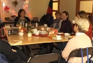 Grupa ośmiu osób dyskutuje przy stole