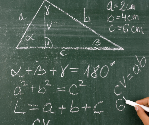 trójkąt i równania matematyczne dotyczące trójkąta zapisane kredą na tablicy