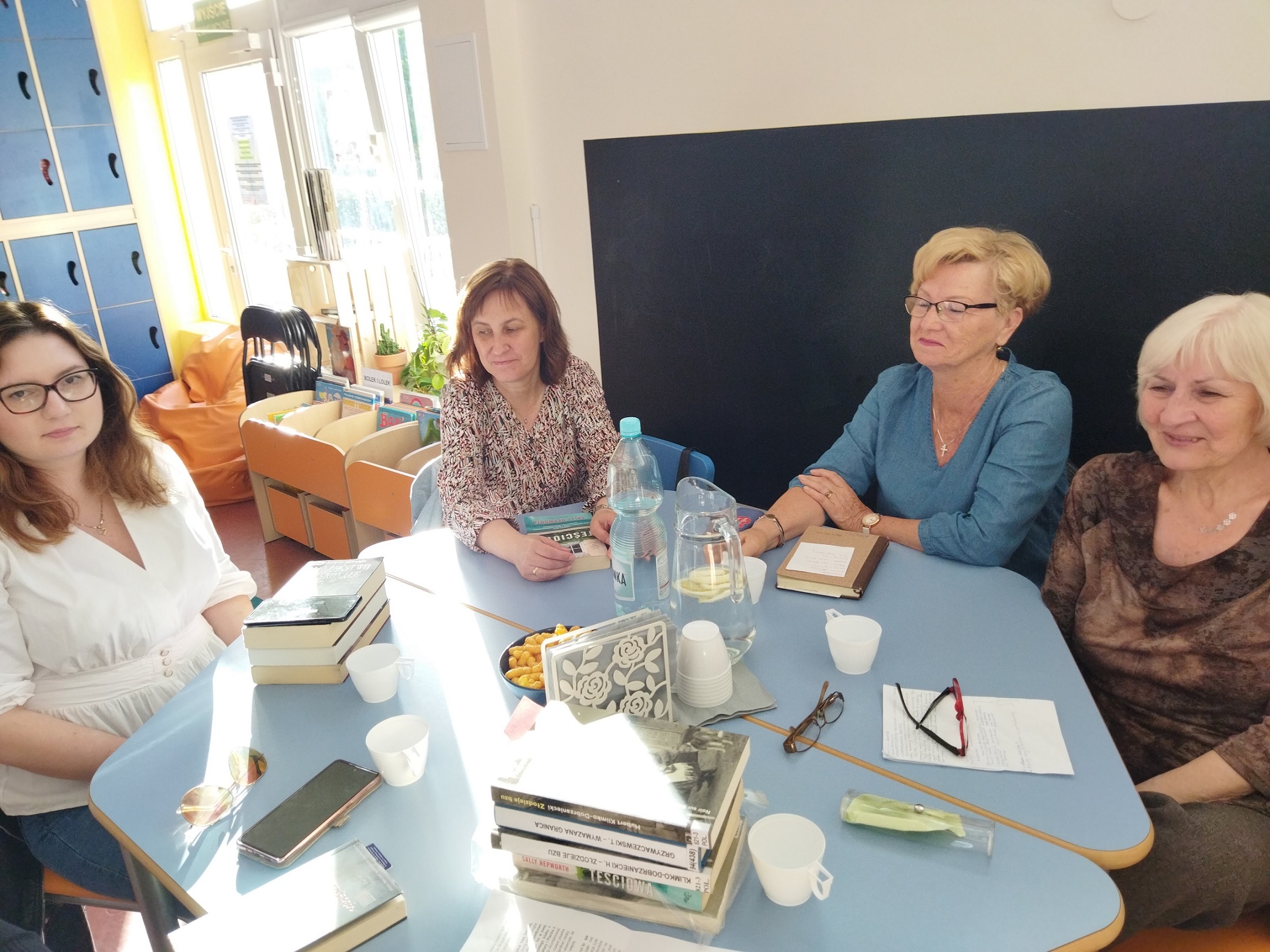 Dyskusyjny Klub Książki cztery kobiety siedzą przy stole, na stole leżą książki