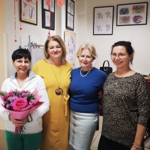 4 kobiety, jedna z nich trzyma bukiet kwiatów