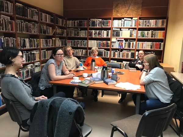 Wodny tancerz kobiety siedzą przy stole w bibliotece i rozmawiają