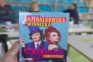 Książka trzymana w dłoni. Na okładce zdjęcia dwóch kobiet. Książka „Jak się starzeć bez godności” Magdaleny Grzebałkowskiej i Ewy Winnickiej.