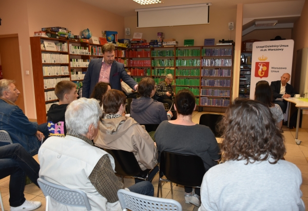 spotkanie z burmistrzem ludzie siedzą na krzesłach w bibliotece