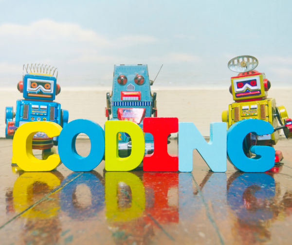 roboty stojące za literami tworzącymi napis "coding"