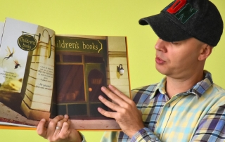 mężczyzna w czapce z daszkiem pokazuje wnętrze książki