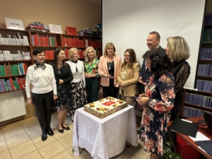 ludzie stoją wokół dużego tortu