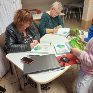 dwie kobiety podpisują książki