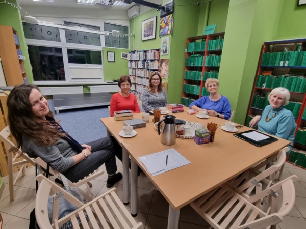 kobiety w bibliotece siedzą wokół stołu