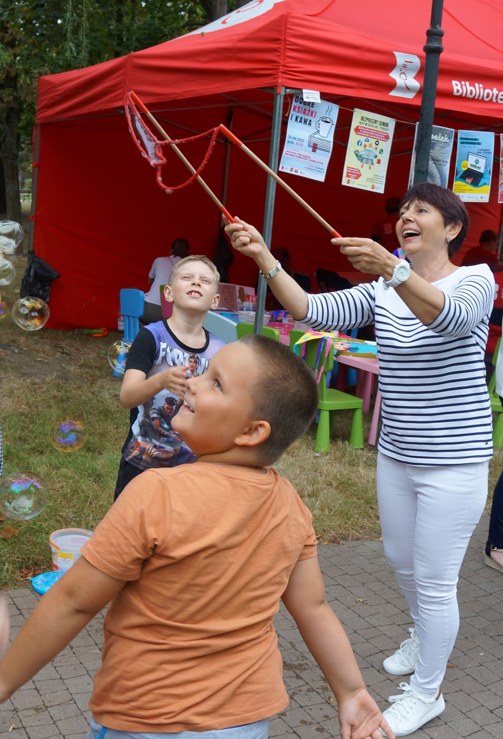 DSC03975 uśmiechnięta kobieta razem z dziećmi puszcza bańki mydlane