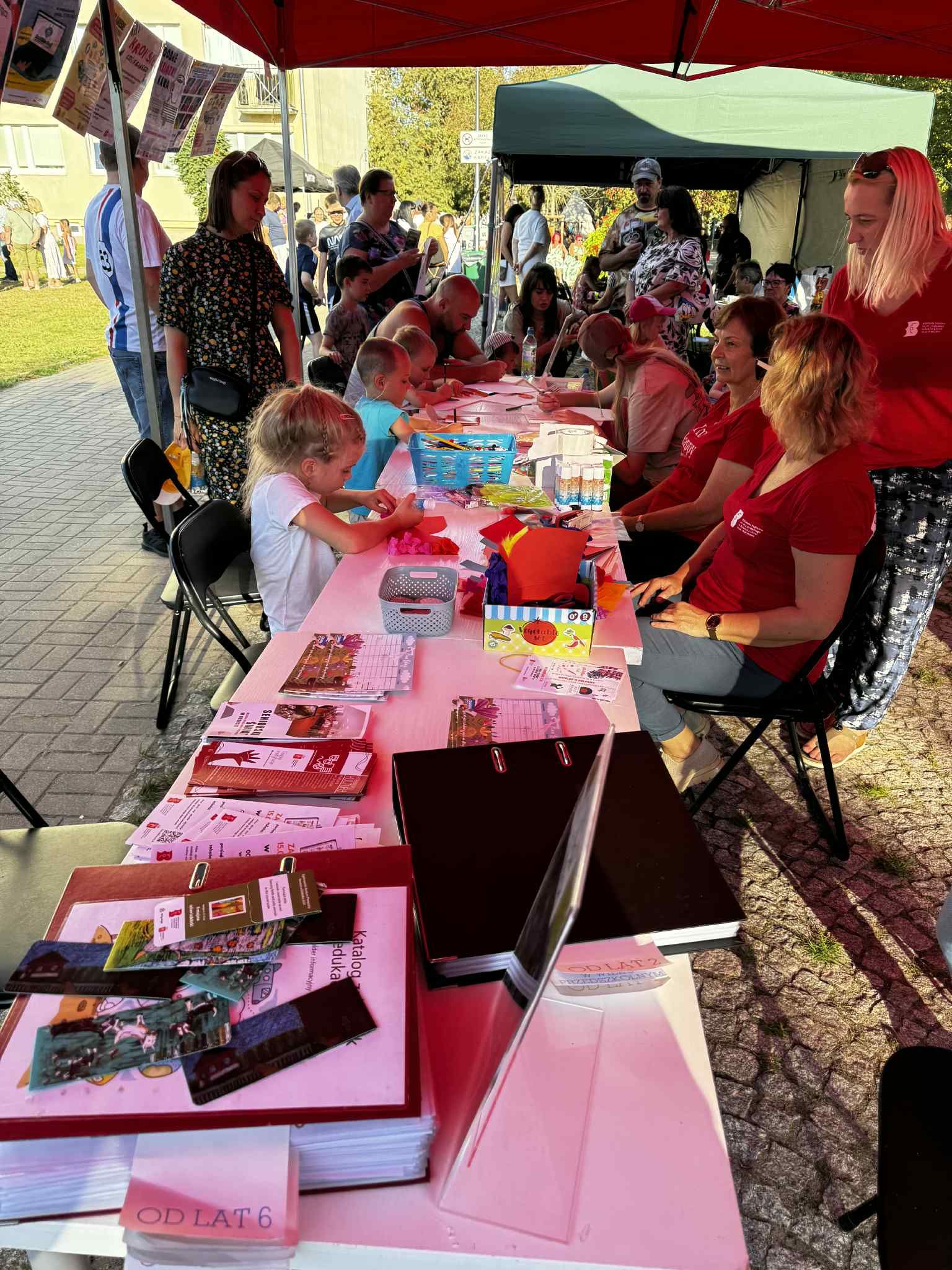 ff7c0782-b8b8-416c-89f4-0d70807929f3 Na białym stoliku rozłożono różne materiały plastyczne: papier, kredki, klej i nożyczki