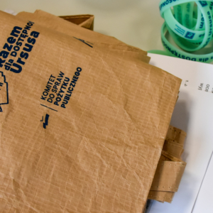 Brązowa torba, obok leży kilka zielonych opasek