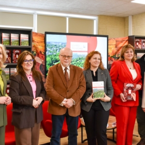 Grupa ludzi stoi przed ekranem, angażując się w prezentację lub dyskusję.