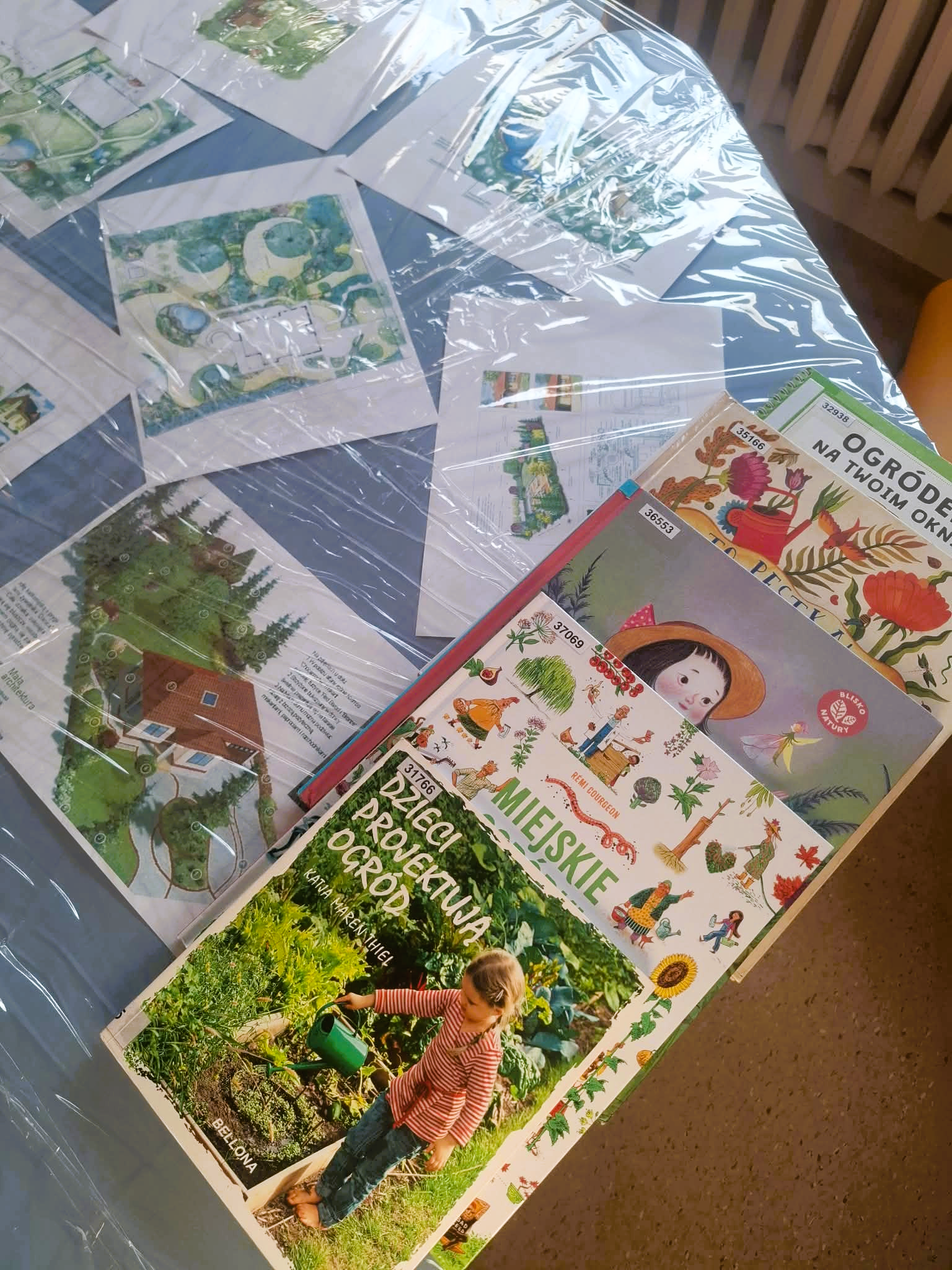 Biblioteka. (1) Stół z kilkoma książkami dla dzieci ułożonymi w rzędy