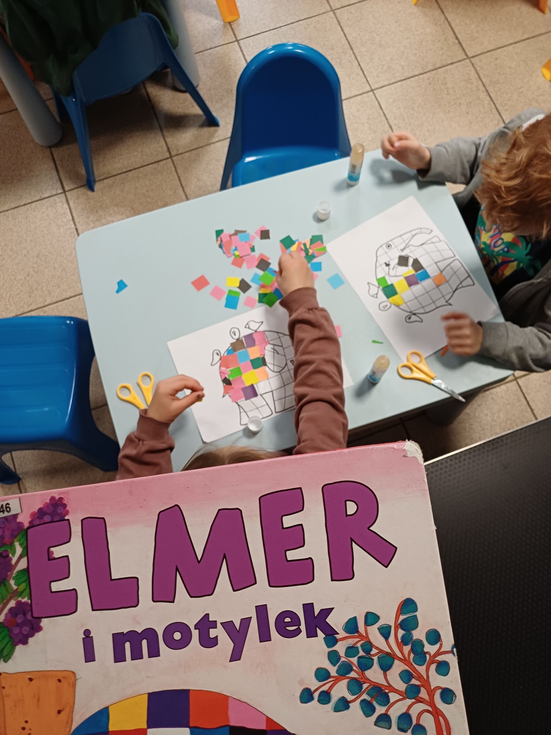 20251016_102439 Dzieci, które wyklejają postać słonia z kolorowych kwadracików papieru kolorowego.