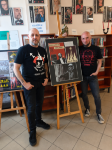 Dwaj mężczyźni stoją obok plakatu w bibliotece.