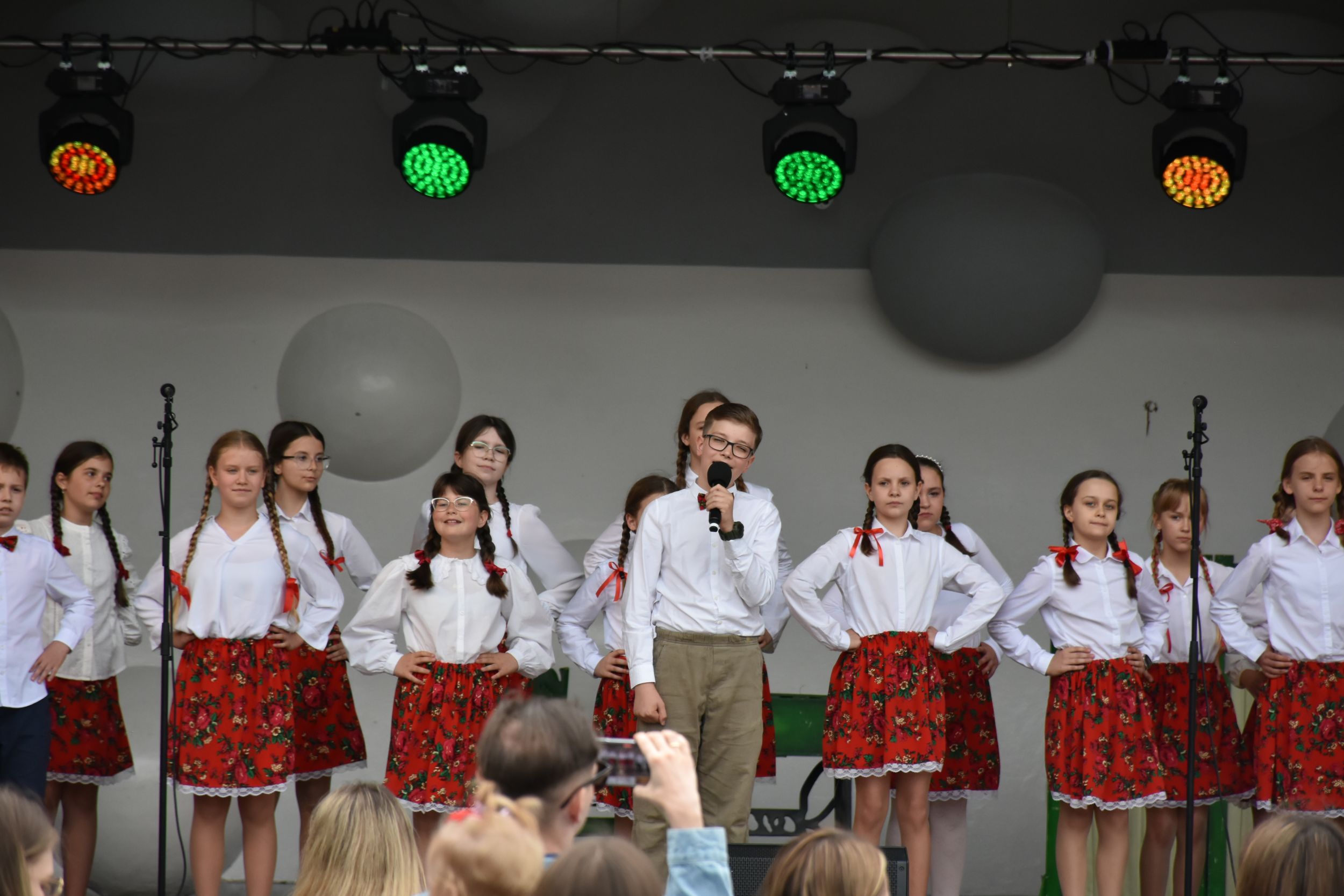 DSC_2278 Grupa dzieci śpiewa i tańczy na scenie.