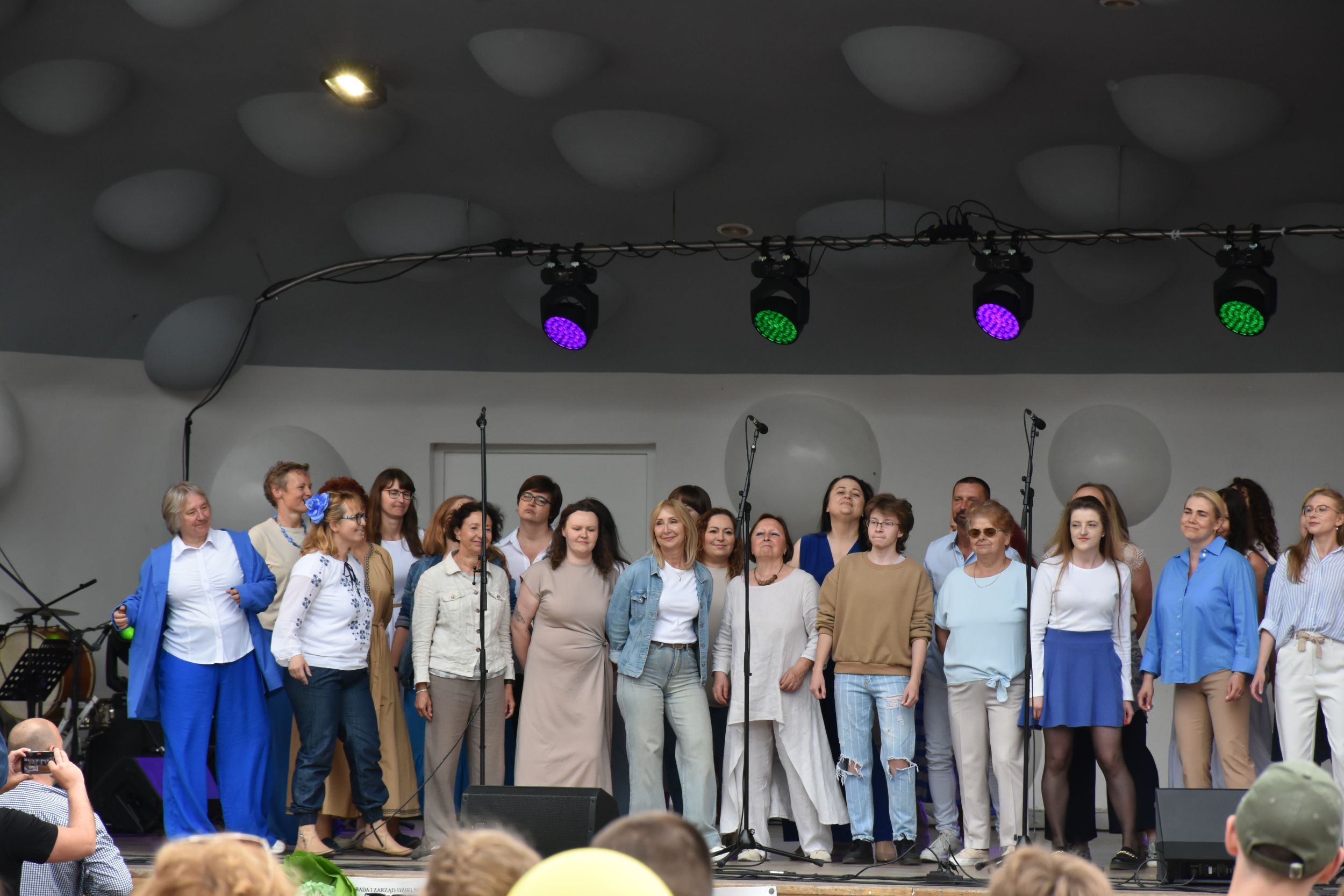 DSC_2323 Grupa ludzi śpiewa i tańczy na scenie.